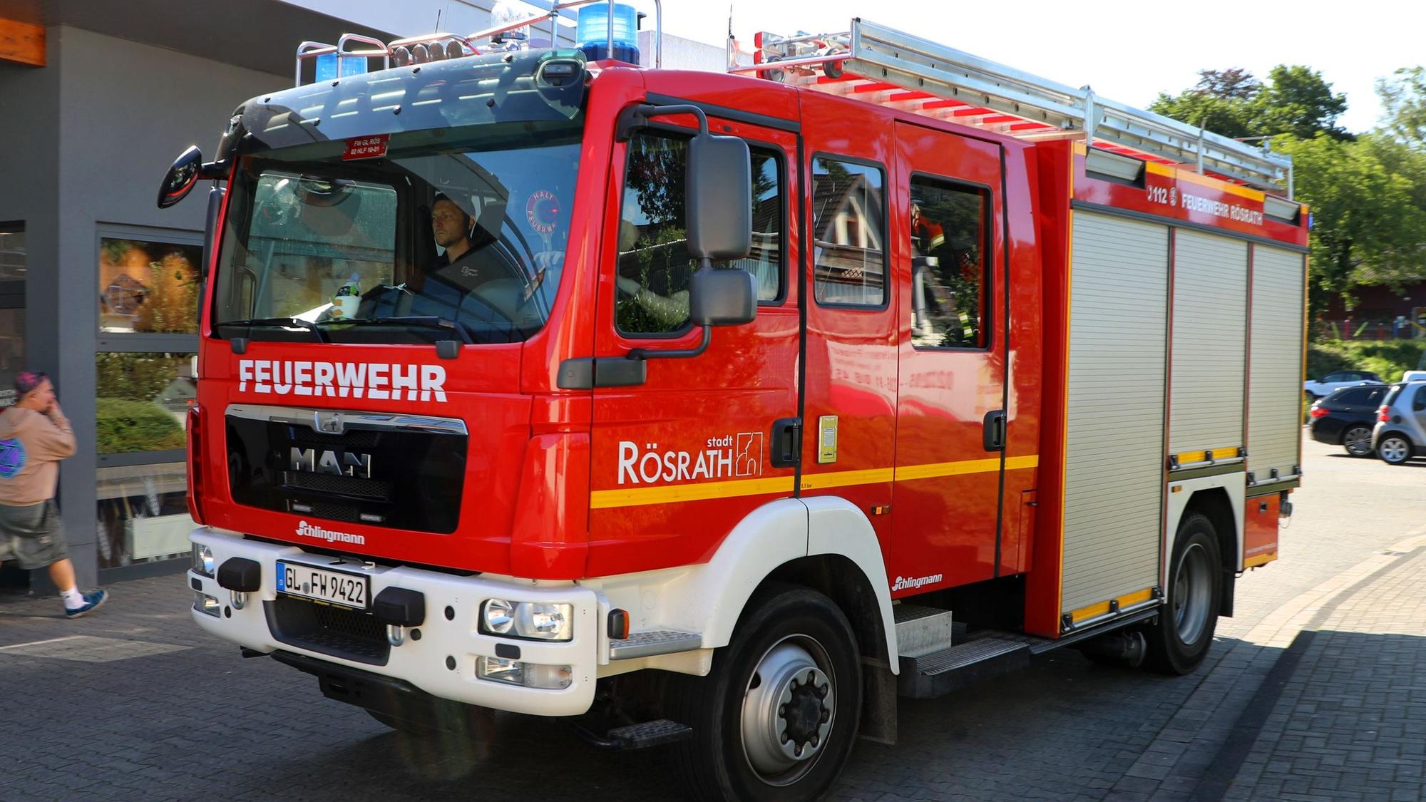 Ein Feuerwehrfahrzeug der Feuerwehr Rösrath fährt über eine Straße.