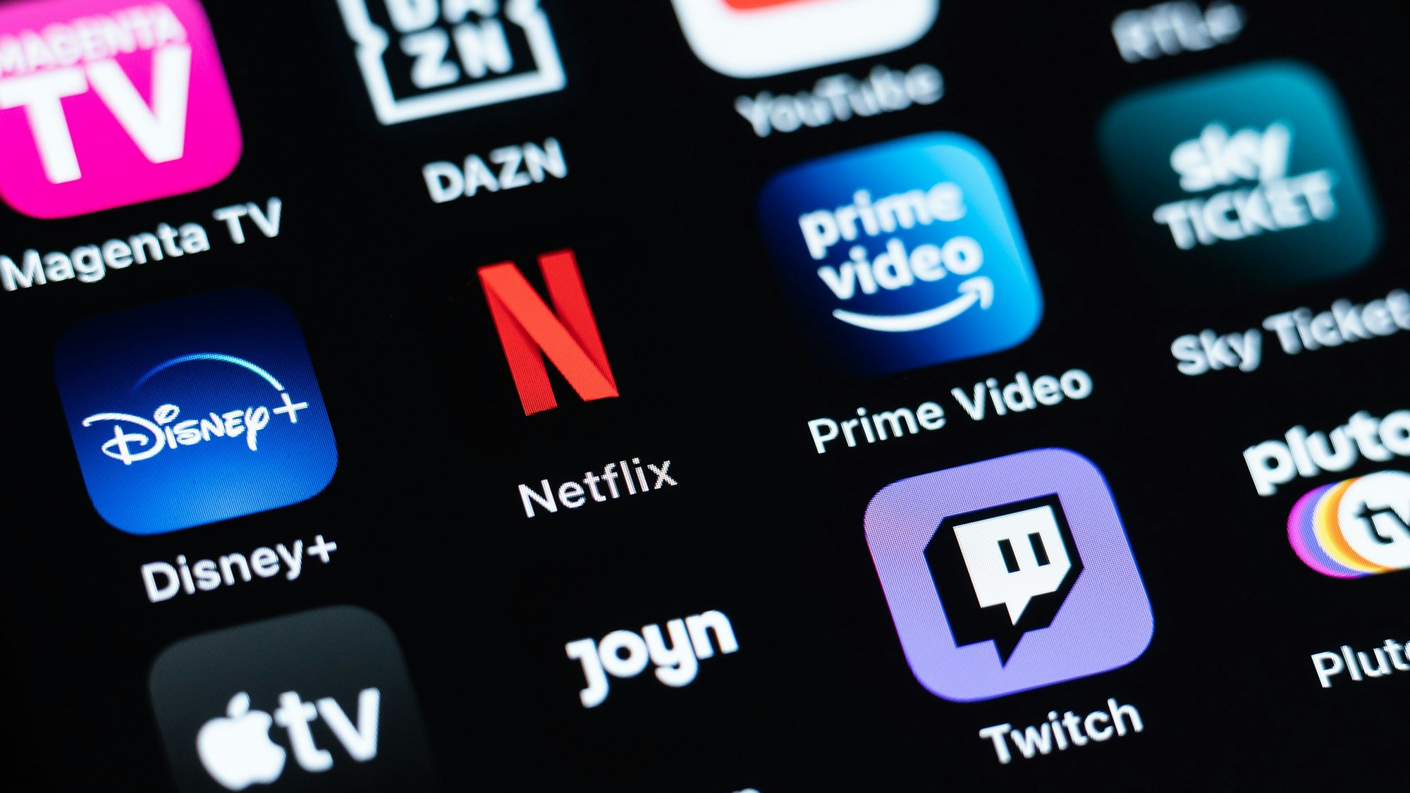 Verschiedene Streaming-Dienste, darunter Magenta TV, DAZN, YouTube, Disney+, Netflix, Prime Video, Sky Ticket, Aplle TV, Joyn, Twitch, sind auf dem Display eines iPhone SE zu sehen.