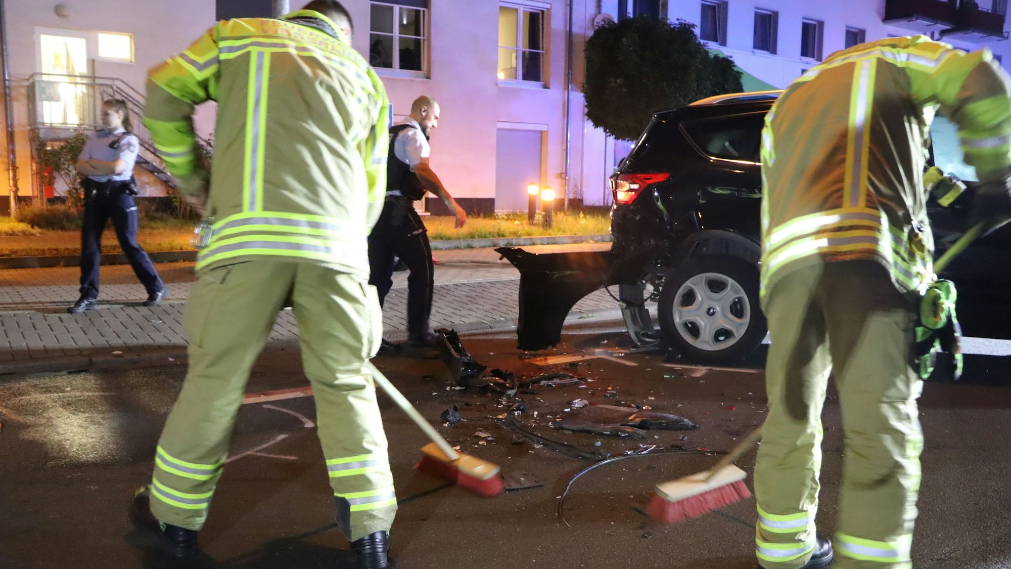 Feuerwehrleute halfen, die Straße von Glassplittern und Fahrzeugteilen zu reinigen.