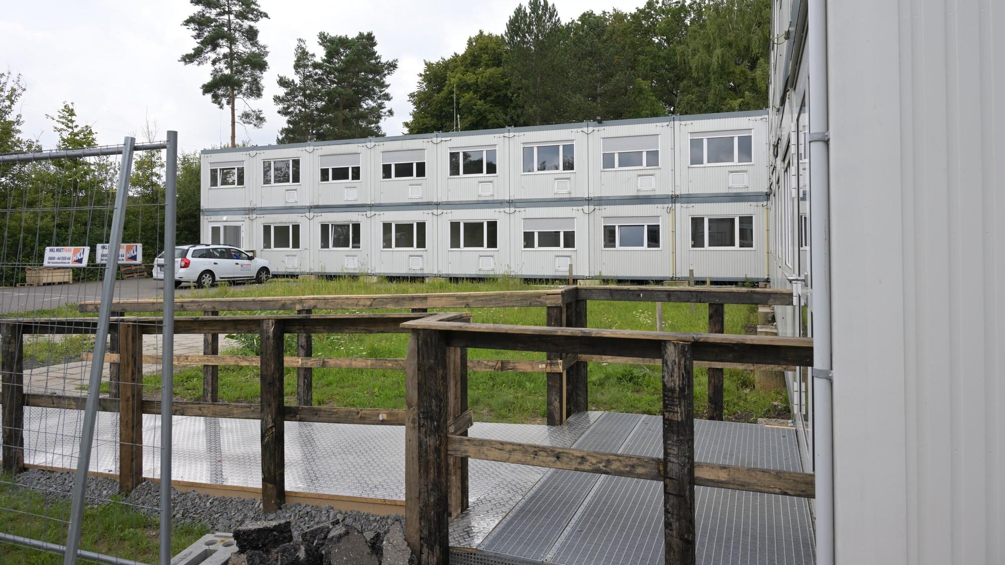 Zu sehen sind zwei Riegel der grauen zweigeschossigen Containerbauten.