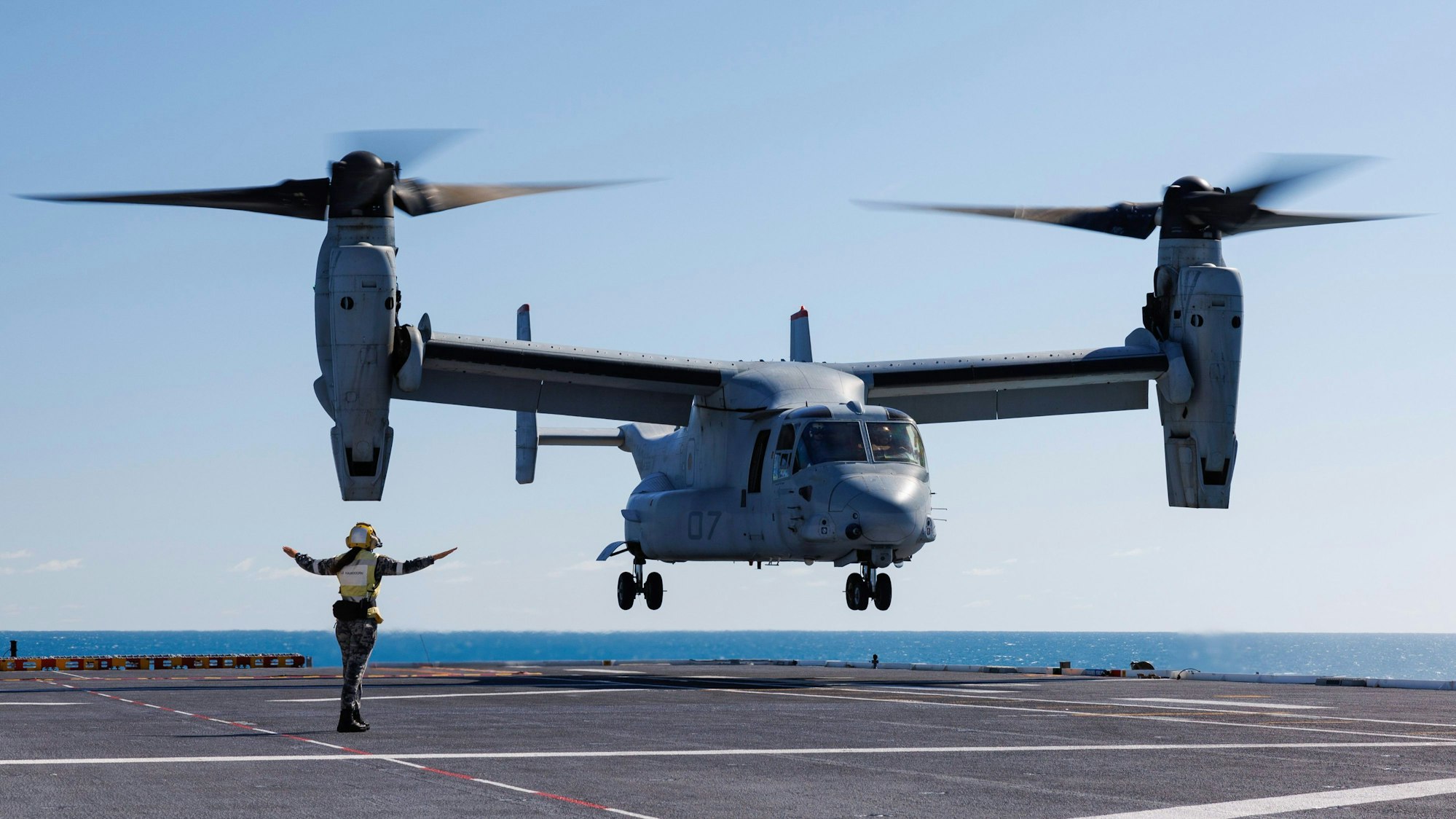 Ein Matrose der Royal Australian Navy führt eine MV-22 Osprey-Maschine des US Marine Corps bei Start- und Landeübungen auf dem Flugdeck der HMAS Adelaide vor der australischen Küste während der Übung «Sea Raider».