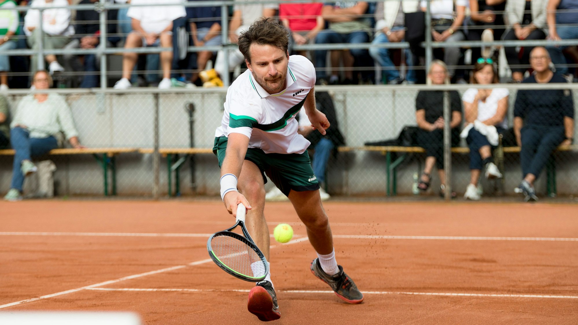 Tennisspieler Yannik Reuter mcht sich lang, um den Ball noch mit dem Schläger erwischen zu können.