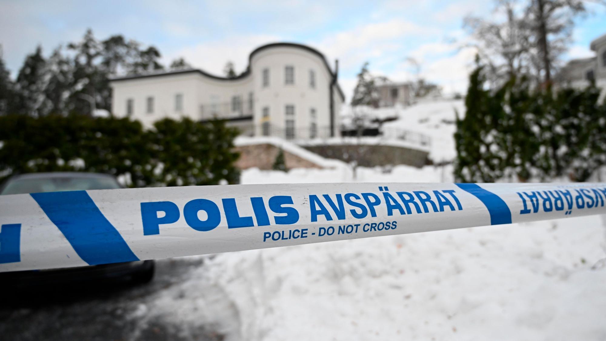 Absperrband der Polizei sichert einen Bereich vor einem Haus ab.