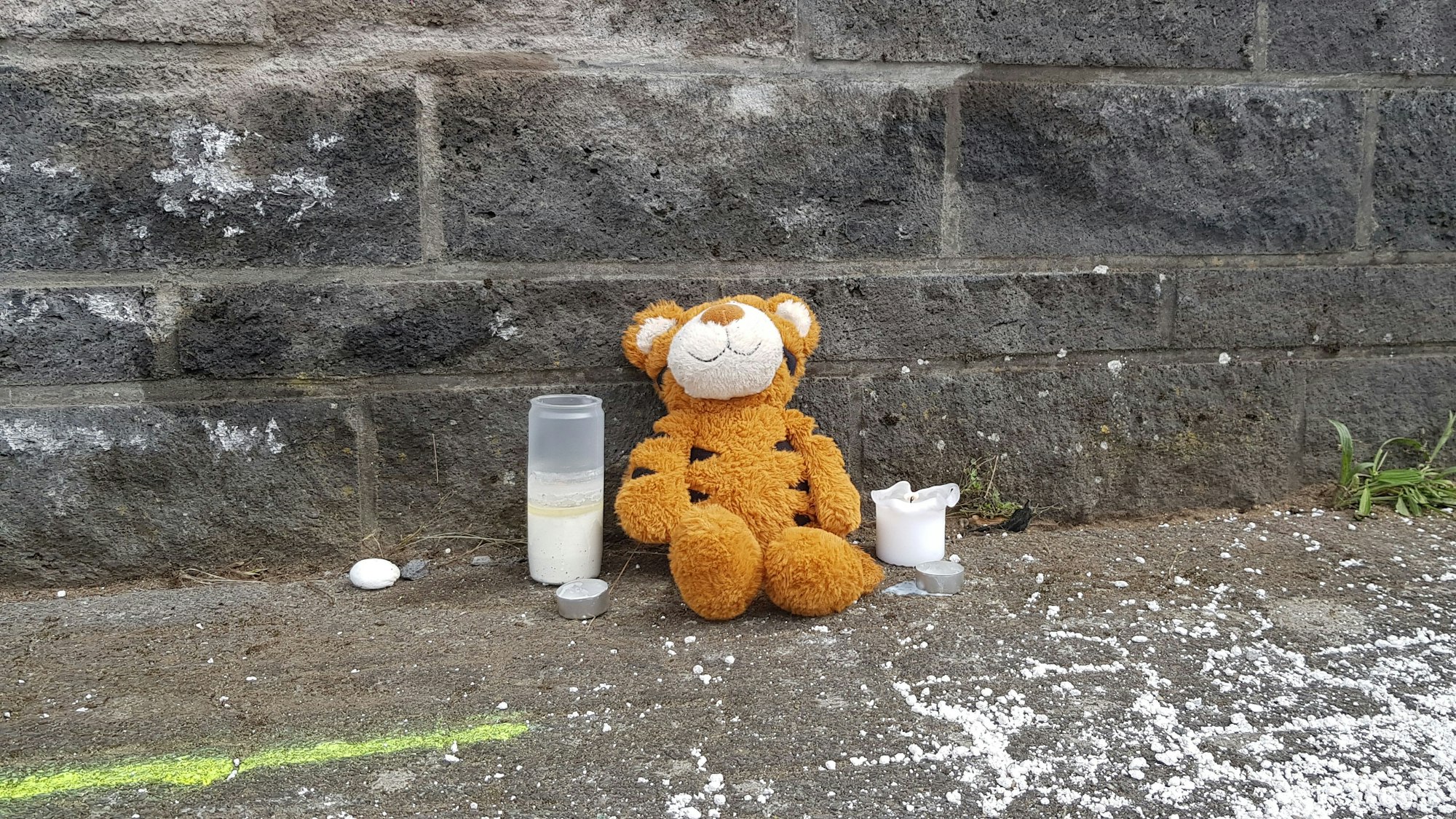 An der Unfallstelle sitzt ein Stofftiger, außerdem wurden vier Kerzen aufgestellt. Die Polizei wertet die Mobiltelefone aller Fahrzeuginsassen aus, um den Hergang zu klären.