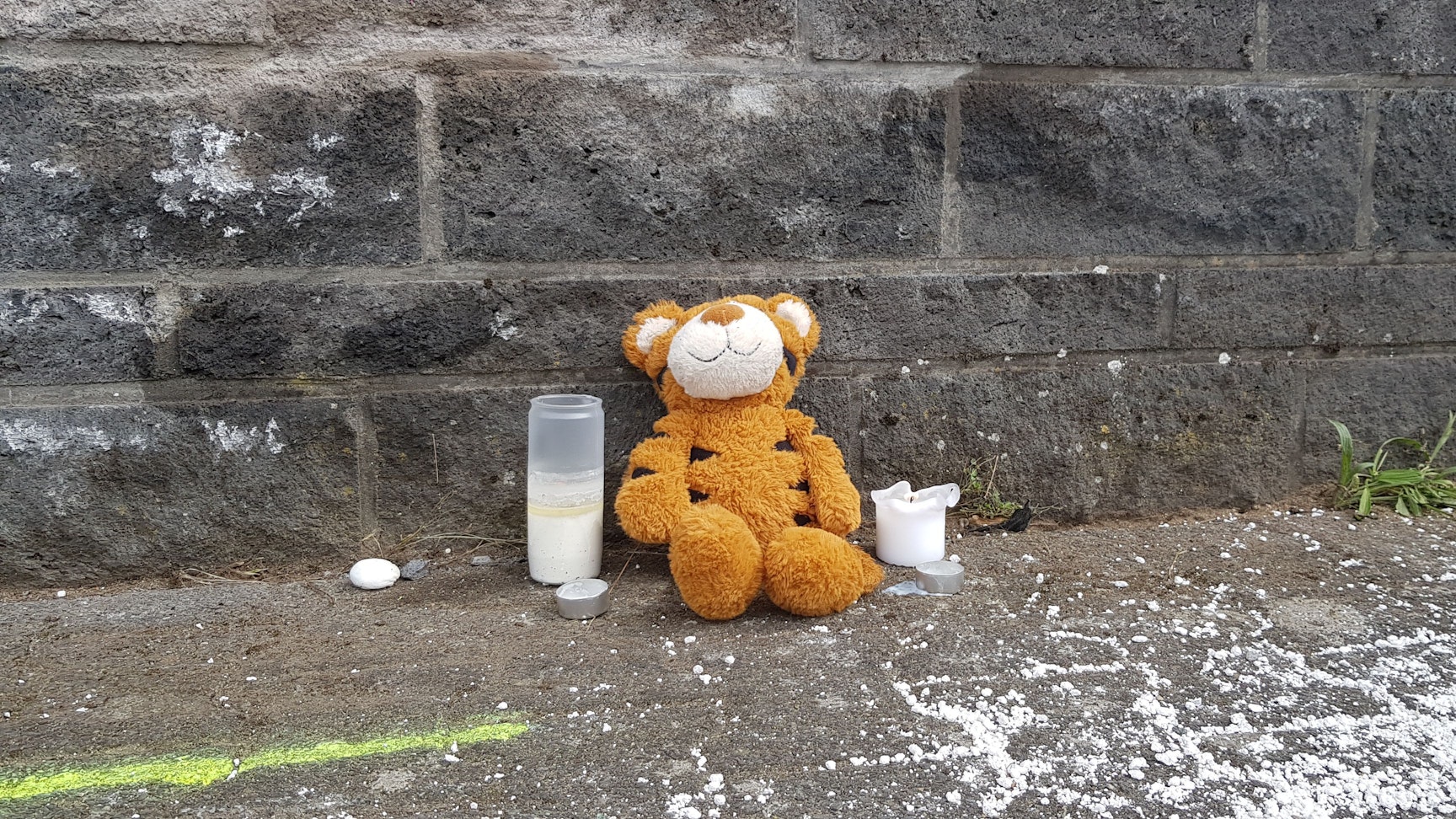 An der Unfallstelle sitzt ein Stofftiger, außerdem wurden vier Kerzen aufgestellt. Die Polizei wertet die Mobiltelefone aller Fahrzeuginsassen aus, um den Hergang zu klären.