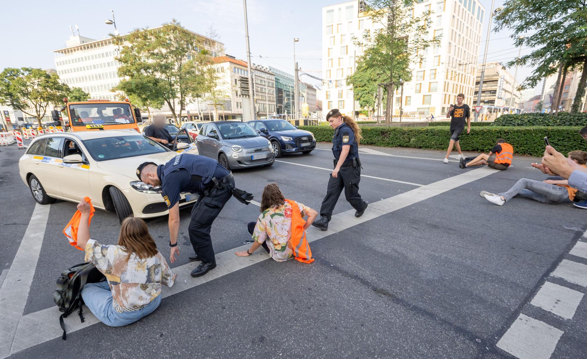 München: Polizisten rennen auf der Kreuzung am Stachus in der Innenstadt zu Teilnehmern· der Letzten Generation, die eine Straße blockieren. (Symbolbild)