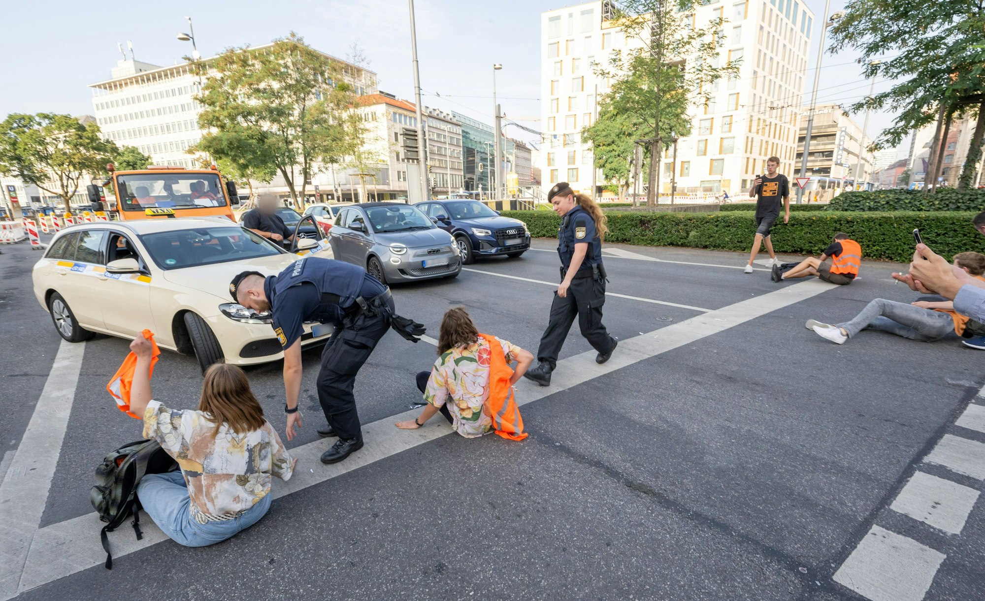 München: Polizisten rennen auf der Kreuzung am Stachus in der Innenstadt zu Teilnehmern· der Letzten Generation, die eine Straße blockieren. (Symbolbild)