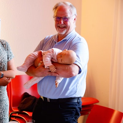 Kursleiterin Dagmar Stapper zeigt einem Teilnehmer, wie man ein Baby hält.