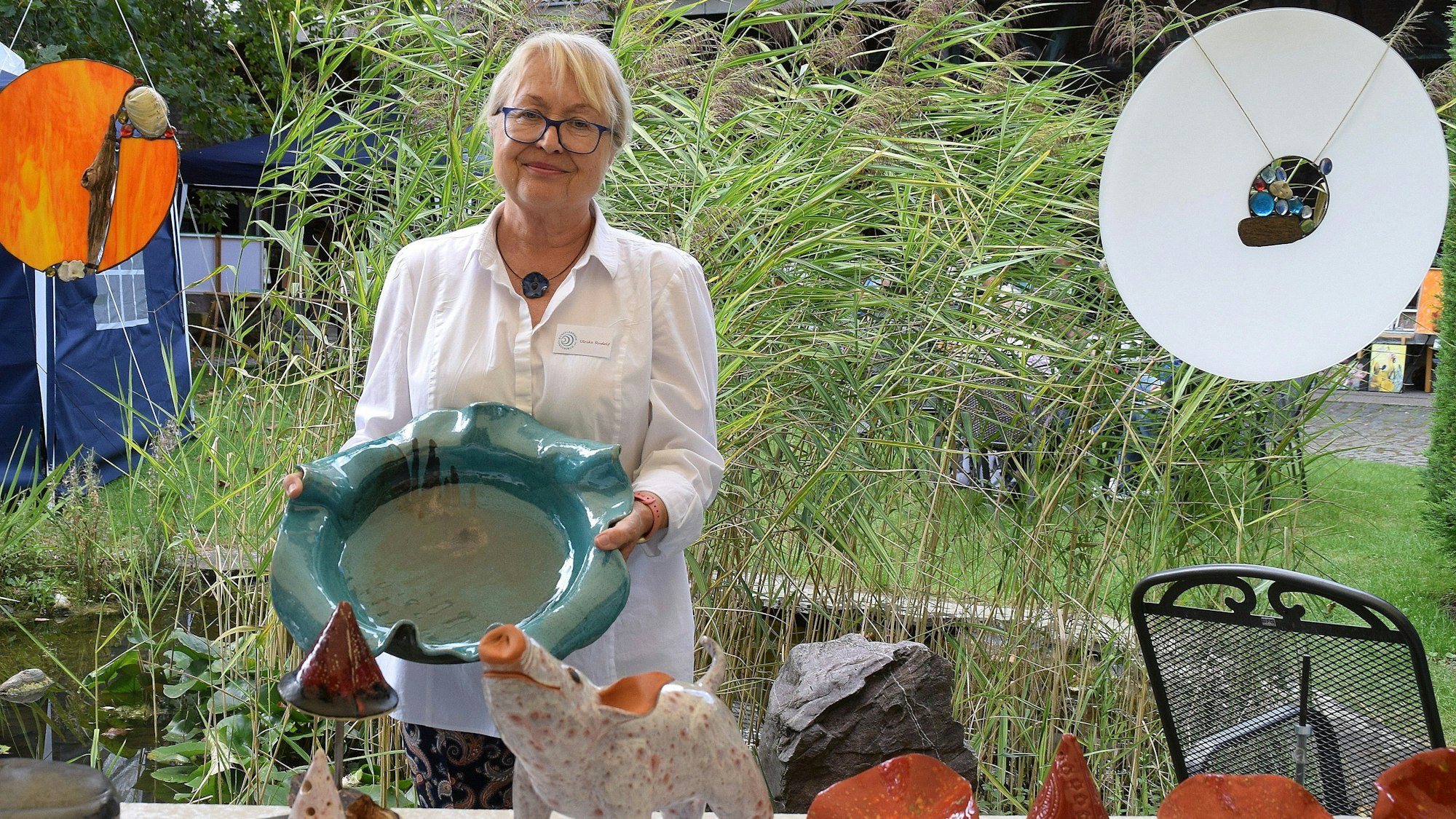 Eine Frau hält eine Schale aus Keramik.