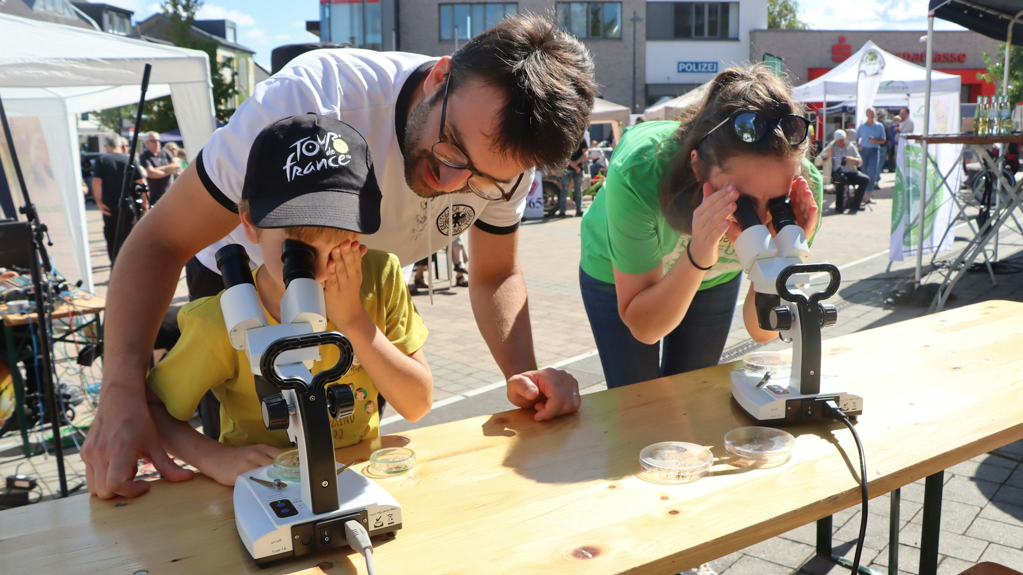 Eine Familie schaut durch ein Mikroskop. Beim ersten Bornheimer Klimatag gab es viel zu entdecken.