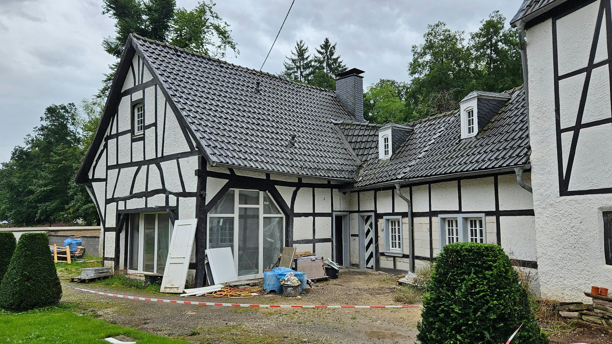 Vor einem Fachwerkhaus stehen noch Reste von Bauschutt.