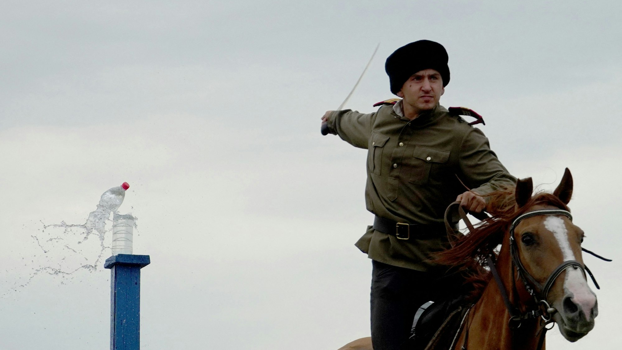 Ein Kosake zu Pferd zerschlägt mit einem Säbel mit Wasser gefüllte Plastikflaschen während eines Säbelschneidewettbewerbs in Region Rostov.