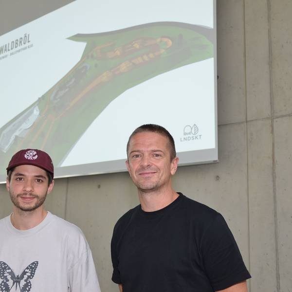 Daniel Schreitmüller (links) und Tobias Hunger von der Landskate GmbH in Köln planen den Rollsport an der Klus in der Ortschaft Niederhof. Jetzt haben sie in Waldbröls Bürgerdorf am Alsberg ihre Pläne in 3D vorgestellt. Sie stehen vor einer Leinwand.