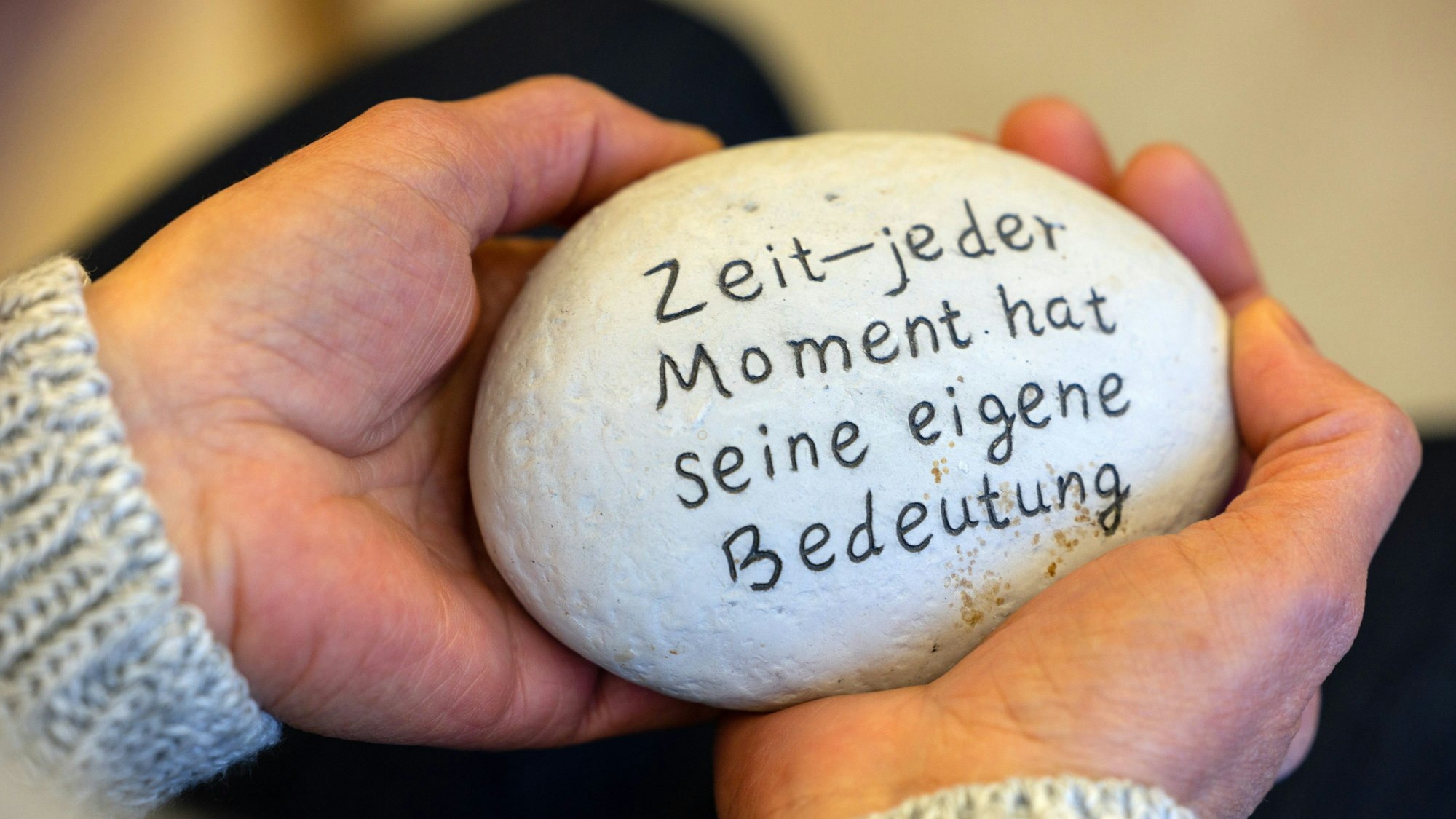Auf einem Stein steht die Botschaft: "Zeit - jeder Moment hat seine eigene Bedeutung."