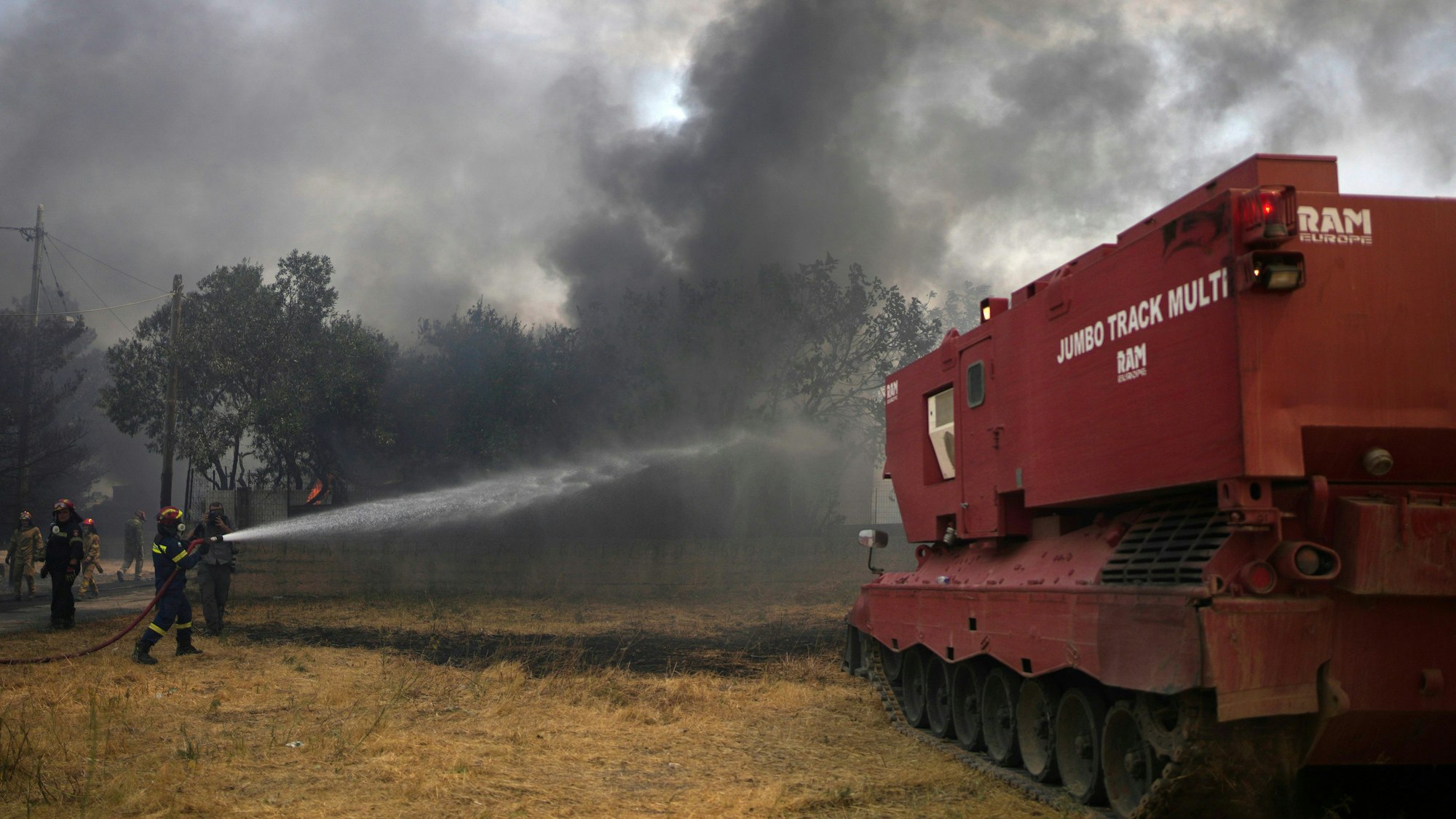 Feuerwehrleute versuchen mit Hilfe eines umgebauten Leopard-Panzers den Waldbrand neben dem christlich-orthodoxen Kloster Agia Paraskevi unter Kontrolle zu bringen. Das Spezialfahrzeug verfügt über eine Kapazität für 15.000 Liter Löschwasser, einer Schaufel für unwegsames Gelände und einer Rettungskammer für zehn Menschen.