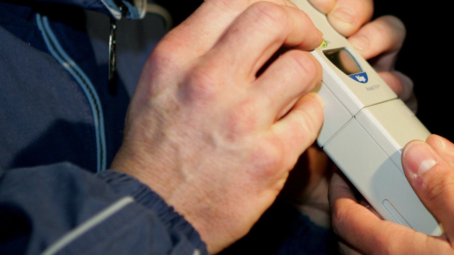 Bei einer männlichen Person wird bei einer Polizeikontrolle ein Alkoholtest durchgeführt. (Symbolbild)