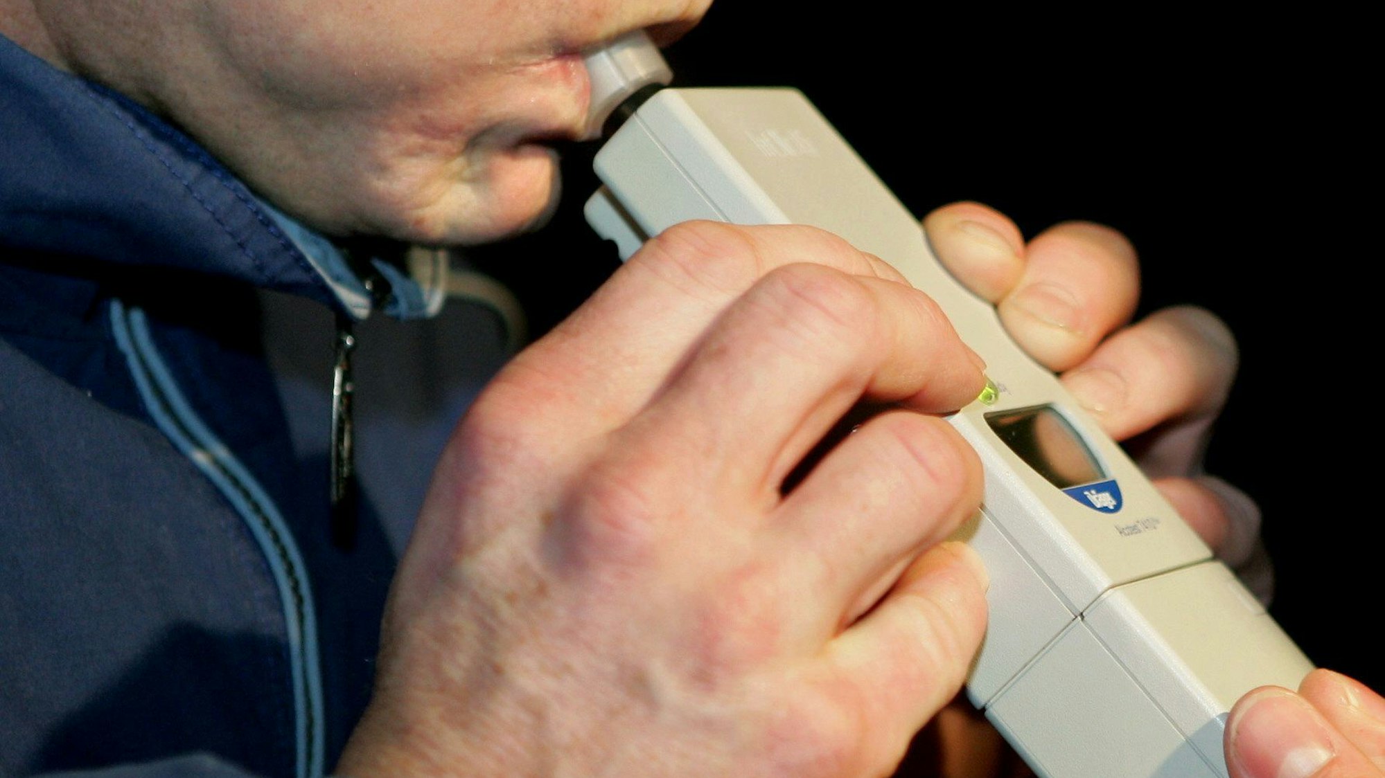 Bei einer männlichen Person wird bei einer Polizeikontrolle ein Alkoholtest durchgeführt. (Symbolbild)