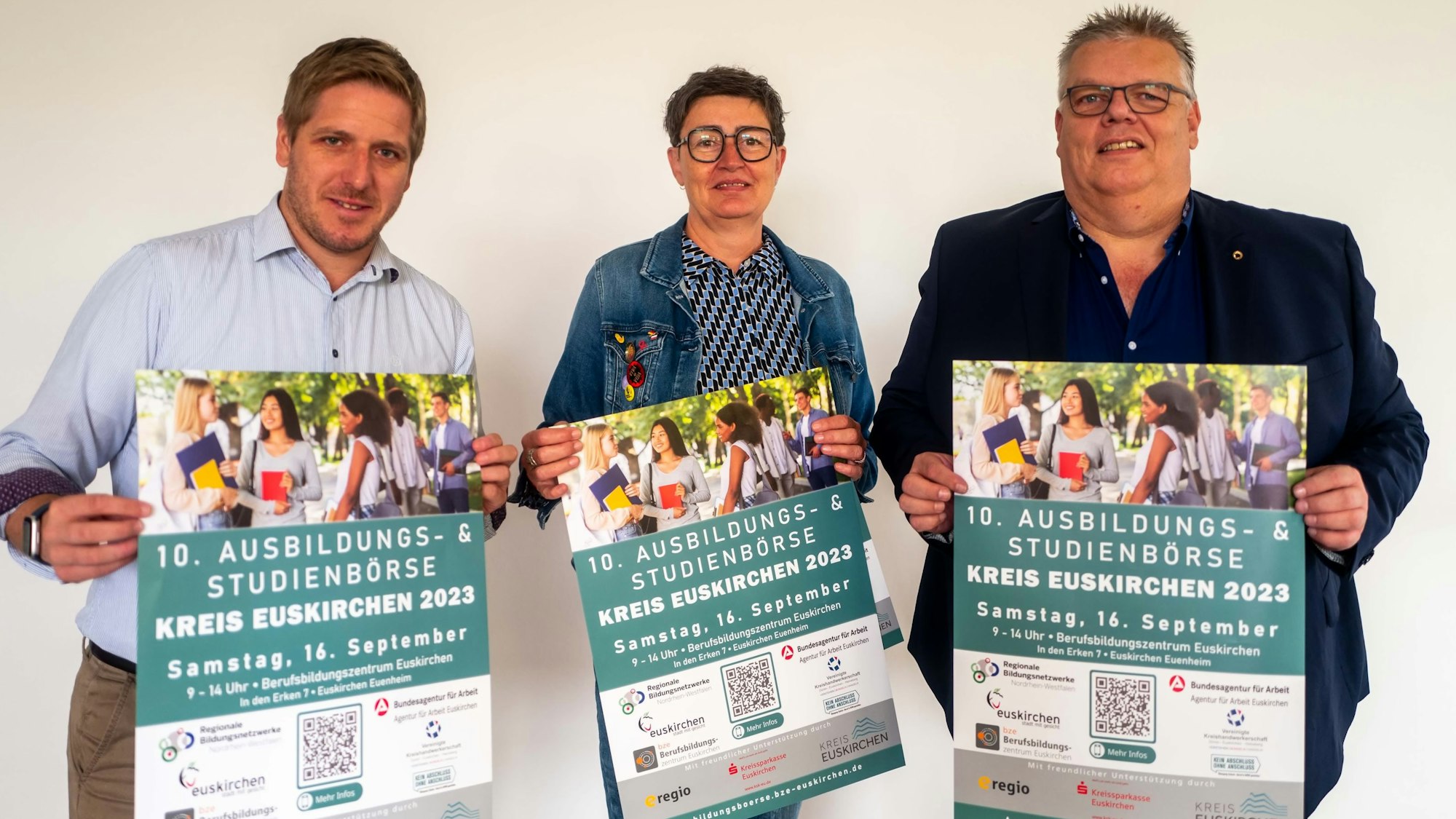 Das Bild zeigt Markus Ramers, Bettina Ismar vom Regioneln Bildungsbüro und Jochen Kupp, Verbandsvorsteher des BZE, wie sie die Plakate hochlaten.