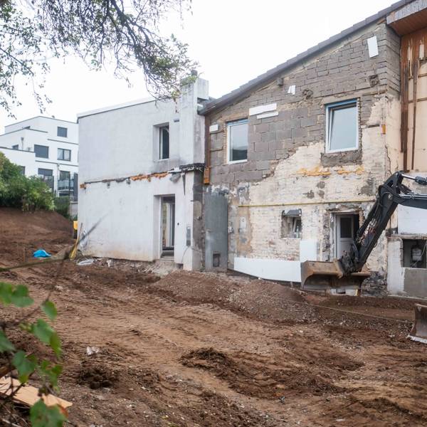Das Bild zeigt einen Bagger, der den Außenbereich des Hauses in Großbüllesheim umgestaltet.