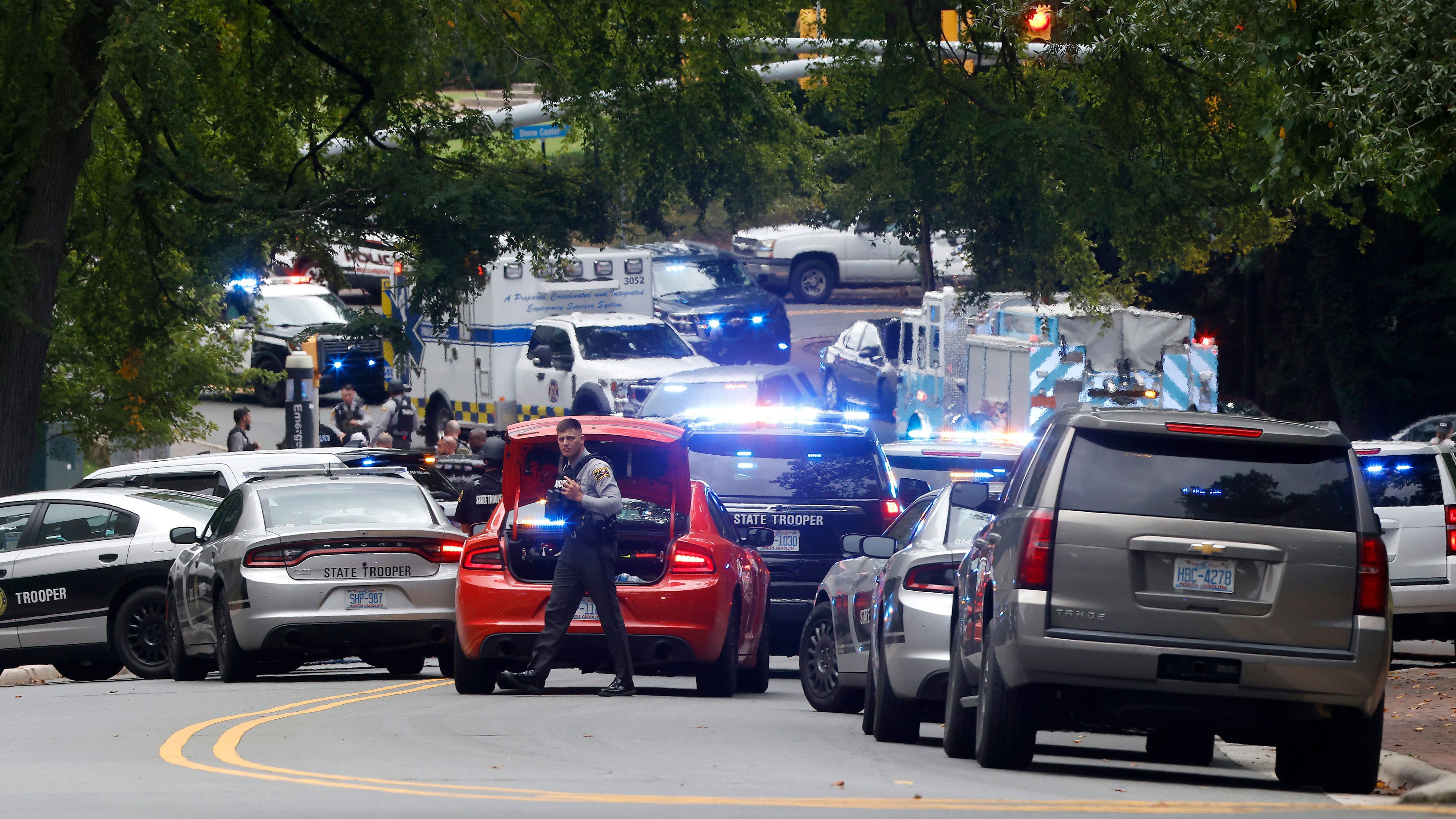 28.08.2023, USA, Chapel Hill: Strafverfolgungsbehörden und Ersthelfer versammeln sich auf der South Street in der Nähe des Glockenturms auf dem Campus der University of North Carolina in Chapel Hill in Chapel Hill, N.C., nachdem eine "bewaffnete und gefährliche Person" auf dem Campus gemeldet wurde.  An einer Universität im US-Bundesstaat North Carolina hat ein Schütze das Feuer eröffnet und ein Mitglied der Fakultät getötet. Foto: Kaitlin McKeown/The News & Observer via AP/dpa - ACHTUNG: Nur zur redaktionellen Verwendung und nur mit vollständiger Nennung des vorstehenden Credits +++ dpa-Bildfunk +++