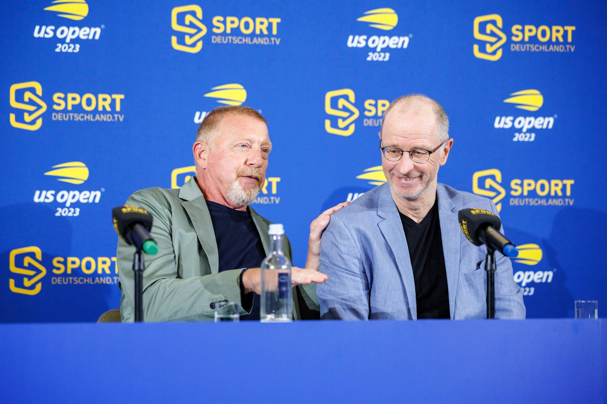 Boris Becker (l), ehemaliger deutscher Tennisspieler, spricht auf der Pressekonferenz. Neben ihm sitzt Matthias Stach, Sportjournalist und Kommentator.