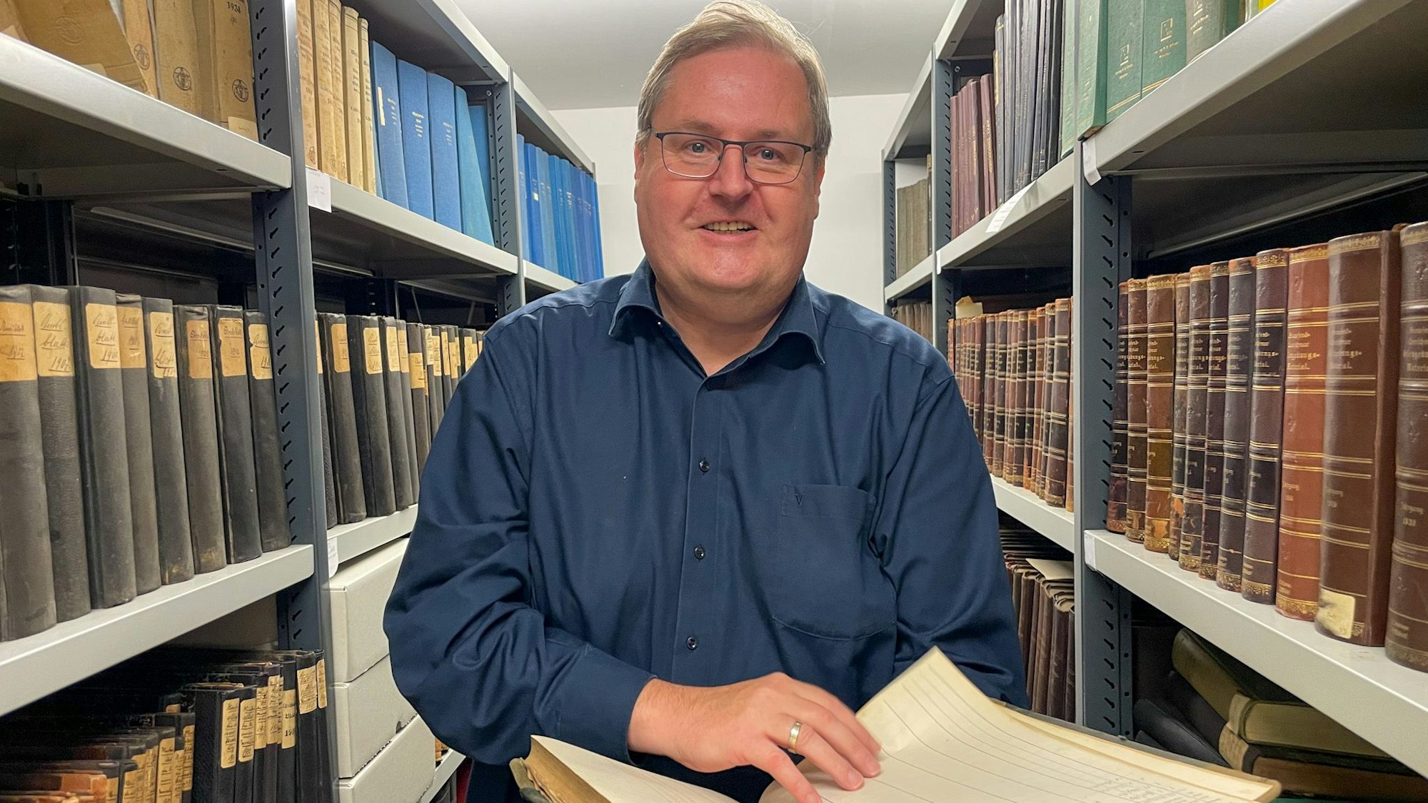 Norbert Bangert blättert im Archiv in einem Buch.