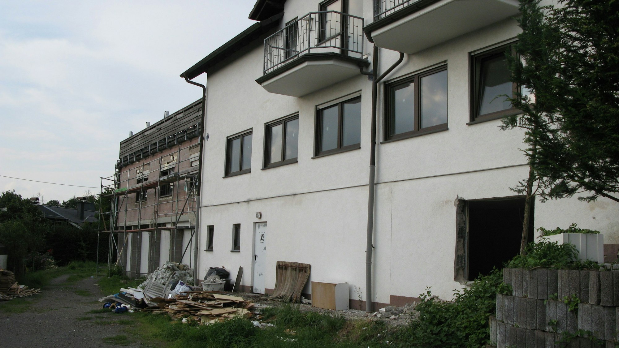 Hinter dem leer stehenden Gebäude liefen Haufen von Schutt und herausgerissenen Einrichtungsgegenständen.