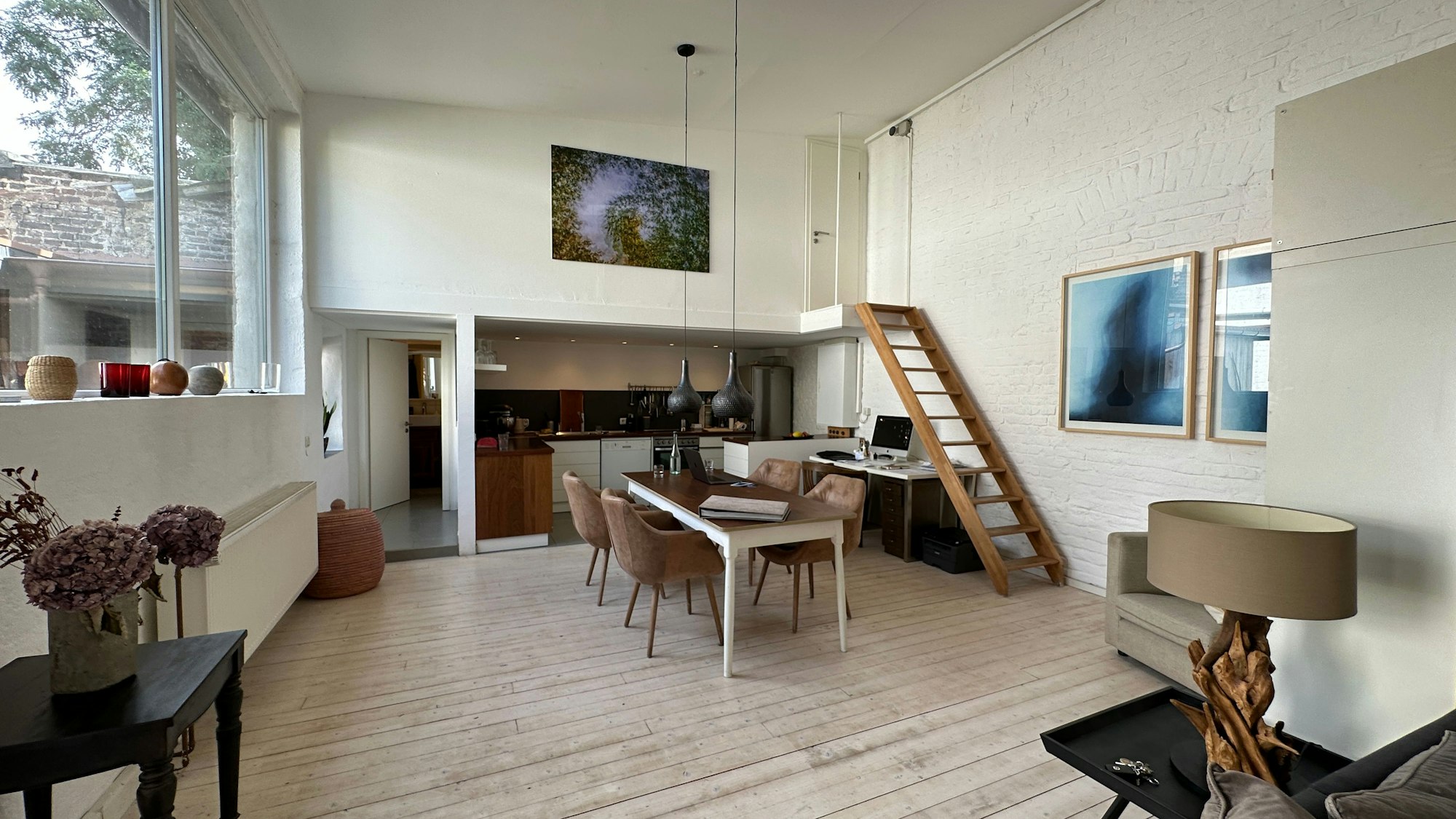 Blick in das Loft des Fotografen Stempell, ein Tisch mit vier Stühlen steht vor einer offenen Küche.