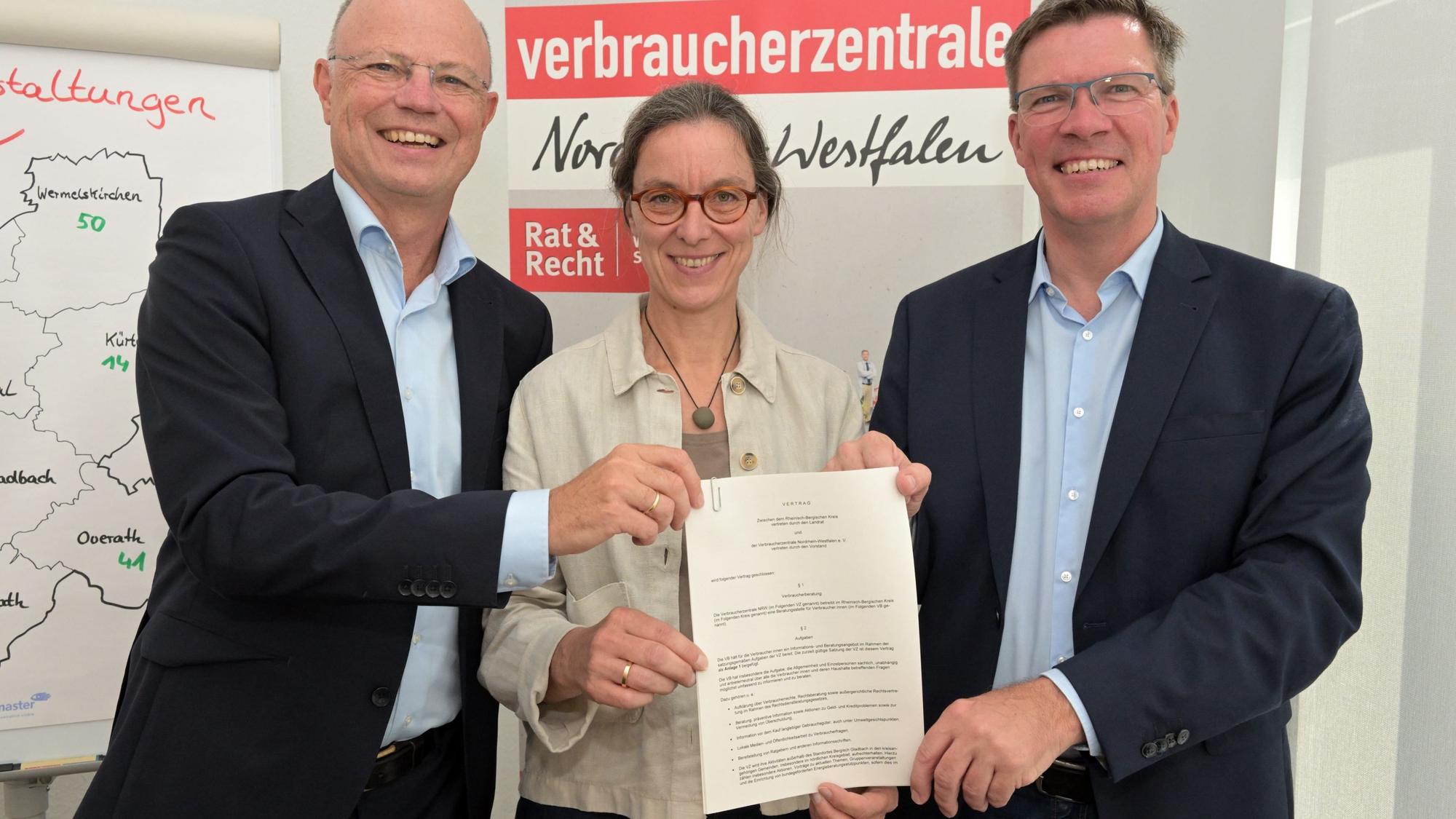 In der Verbraucherzentrale Bergisch Gladbach zeigen (v.l.) Wolfgang Schuldzinski, Brigitte Becker und Landrat Stephan Santelmann den Vertrag.