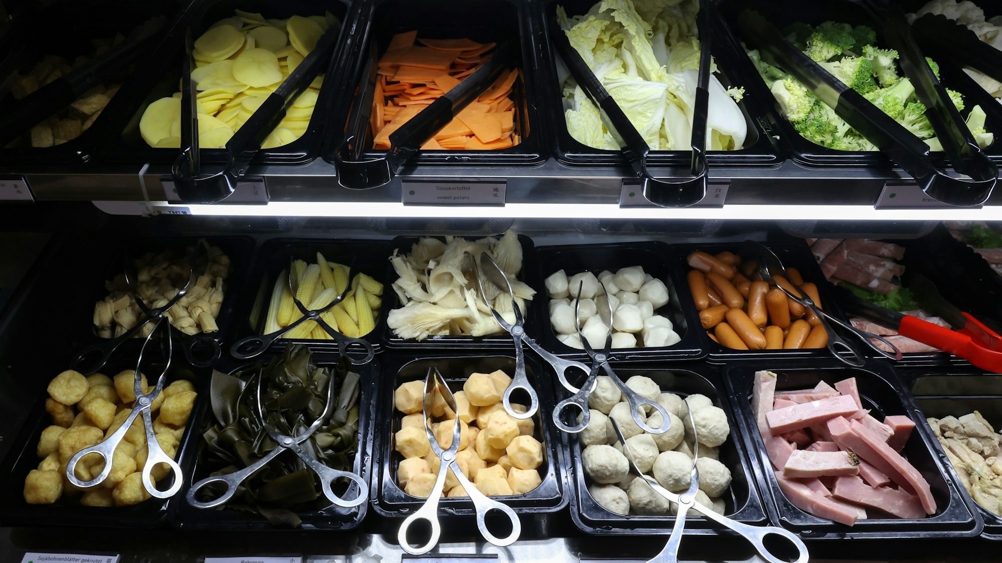 geschnittenes Gemüse und Klöße in schwarzen Behältern