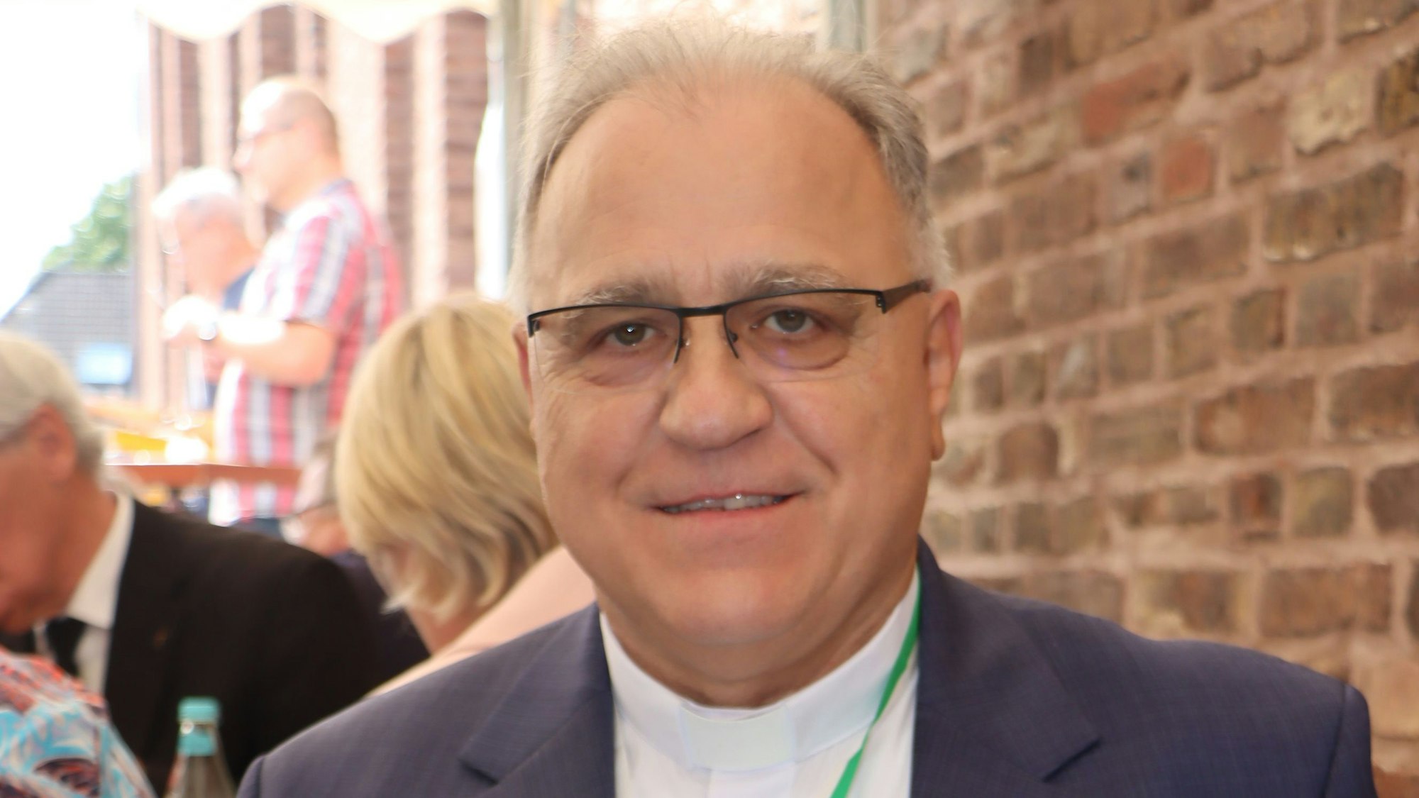 Ein Mann mit Brille lächelt freundlich.