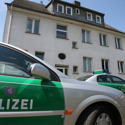 Streifenwagen stehen vor einem Gebäude.