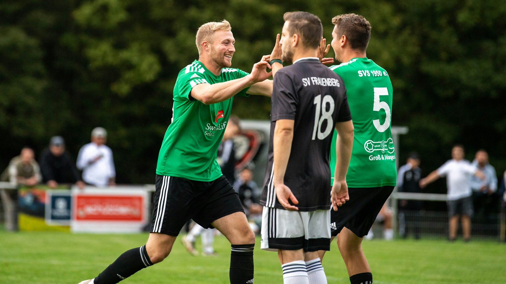 Das Bild zeigt Schöneseiffens Torschützen Max Jöbges, wie er mit einem Mannschaftskollegen abklatscht.