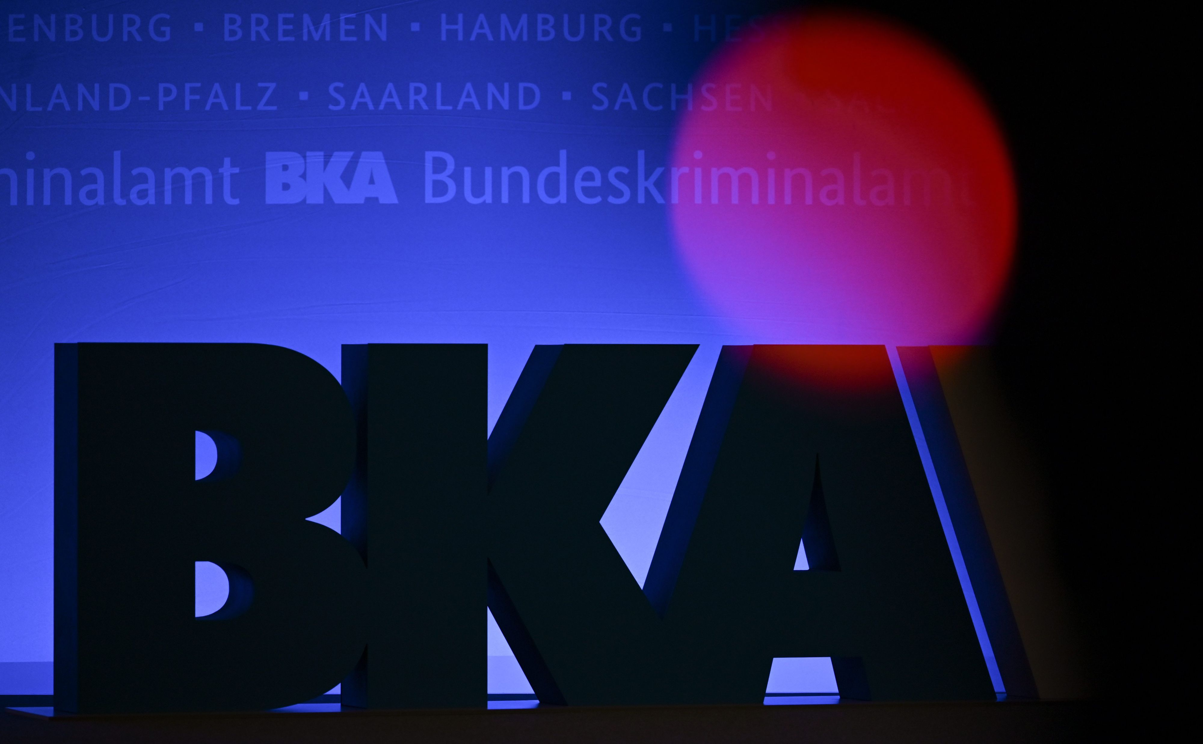 Das Rotlicht einer TV-Kamera leuchtet bei einer Tagung des Bundeskriminalamtes (BKA) im RheinMain CongressCenter in Wiesbaden vor einem großen BKA-Logo.