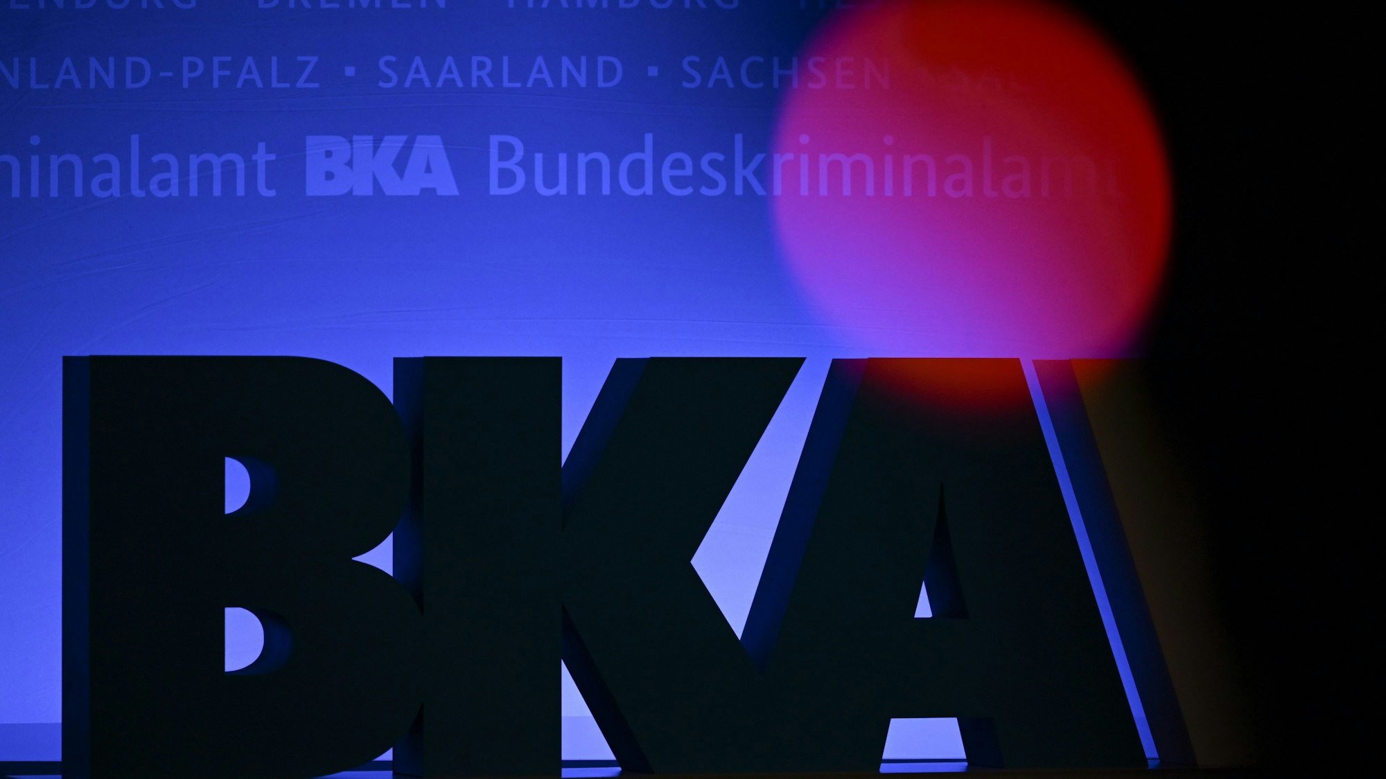 Das Rotlicht einer TV-Kamera leuchtet bei einer Tagung des Bundeskriminalamtes (BKA) im RheinMain CongressCenter in Wiesbaden vor einem großen BKA-Logo.