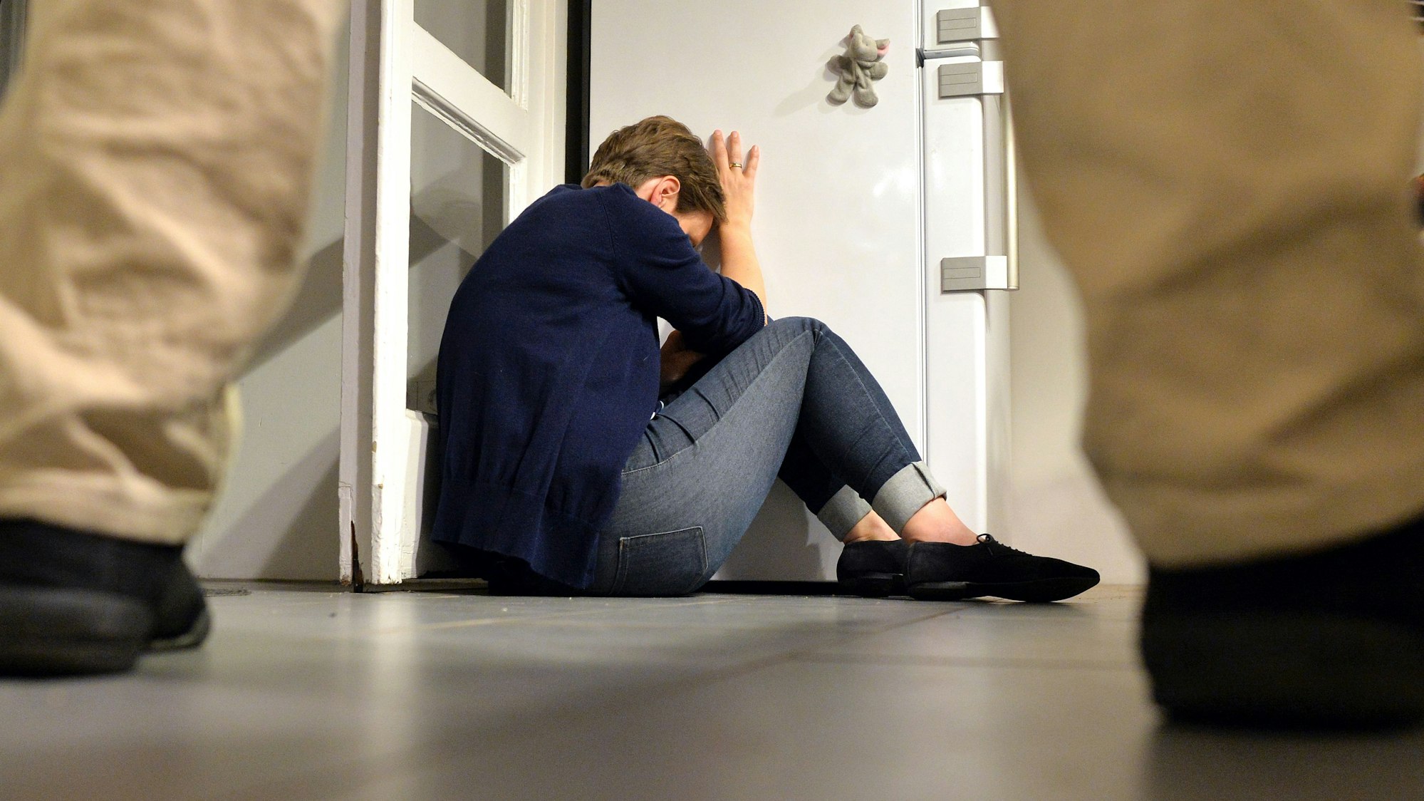 Eine Frau versucht, sich in einer Wohnung vor der Gewalt eines Mannes zu schützen.