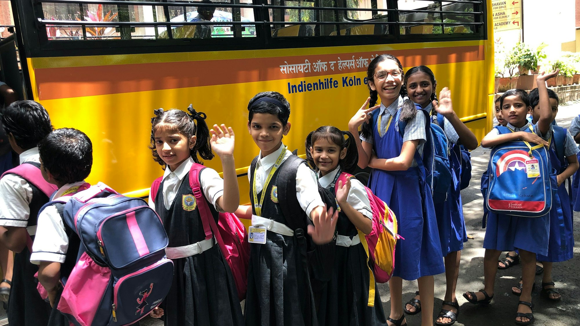 Das Foto zeigt indische Schulkinder vor einem Bus
