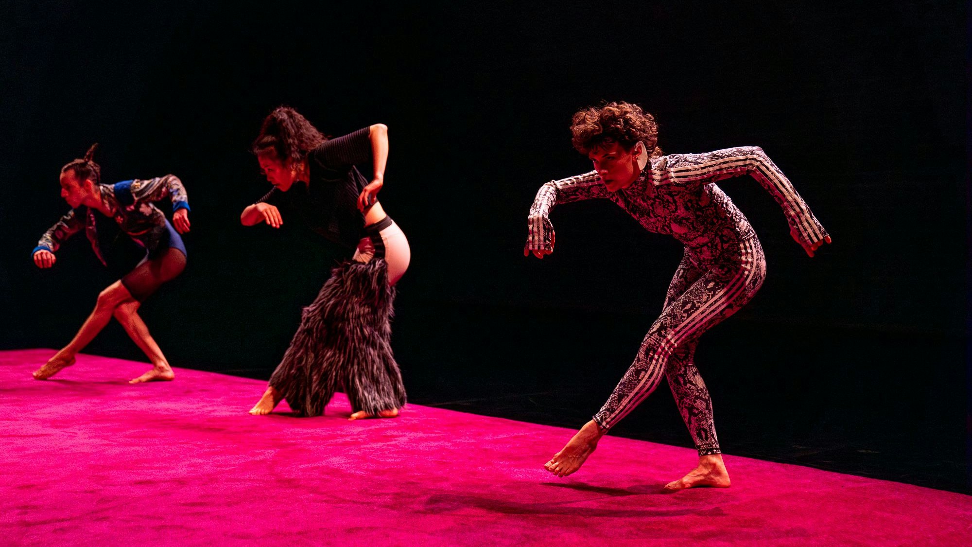 Tänzerin Celine Bellut tanz mit zwei weiteren Darstellerin auf einer roten Bühne.m