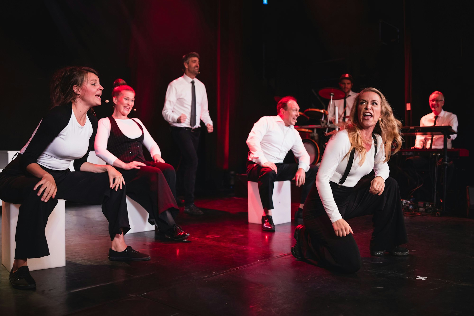 Leute singen auf einer Bühne.
