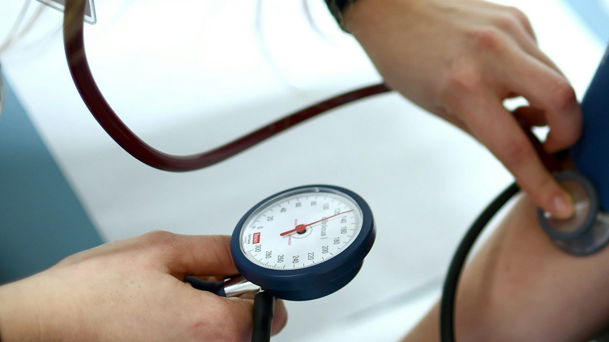 Einem Menschen wird in einer Arztpraxis der Bluthochdruck gemessen. (Symbolbild)