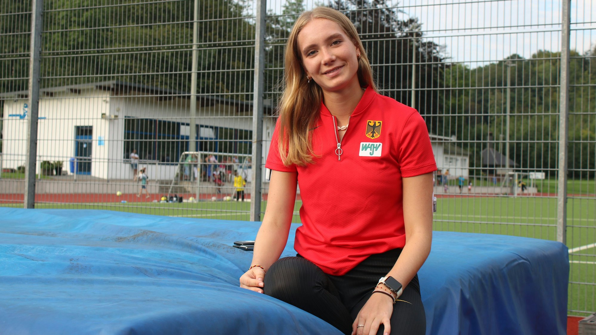 Zu sehen ist eine junge Frau auf einer Leichtathletik-Anlage.