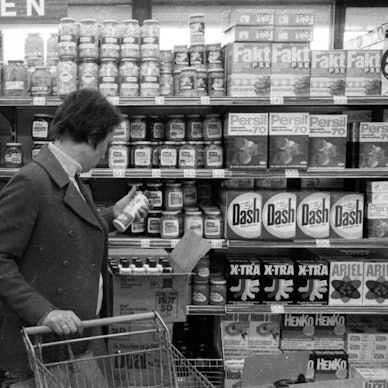 Kunden stehen an einem Regal im Supermarkt.