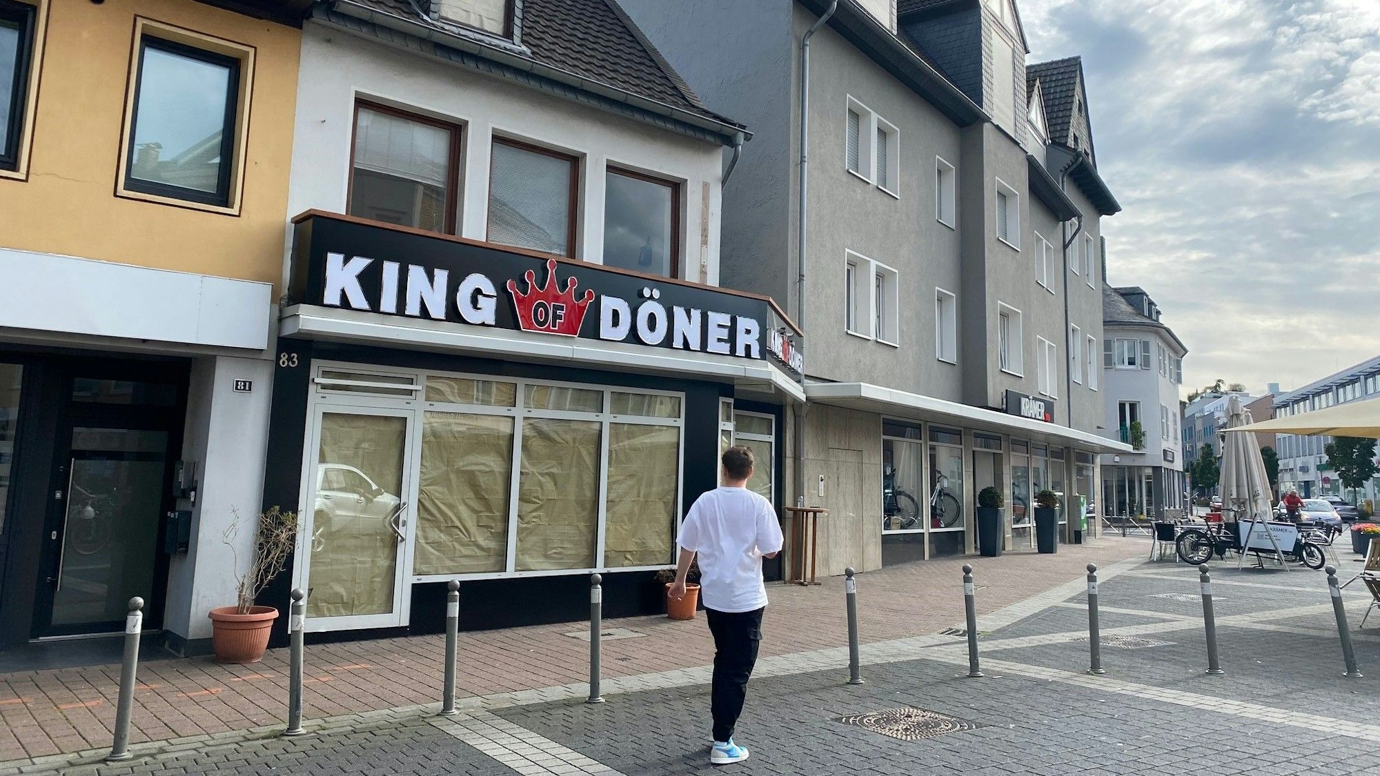 Das Bild zeigt eine Außenansicht des neuen Restaurants. Noch sind die Scheiben abgeklebt. Über der Tür steht die große Leuchtreklame mit dem Schriftzug King of Döner.