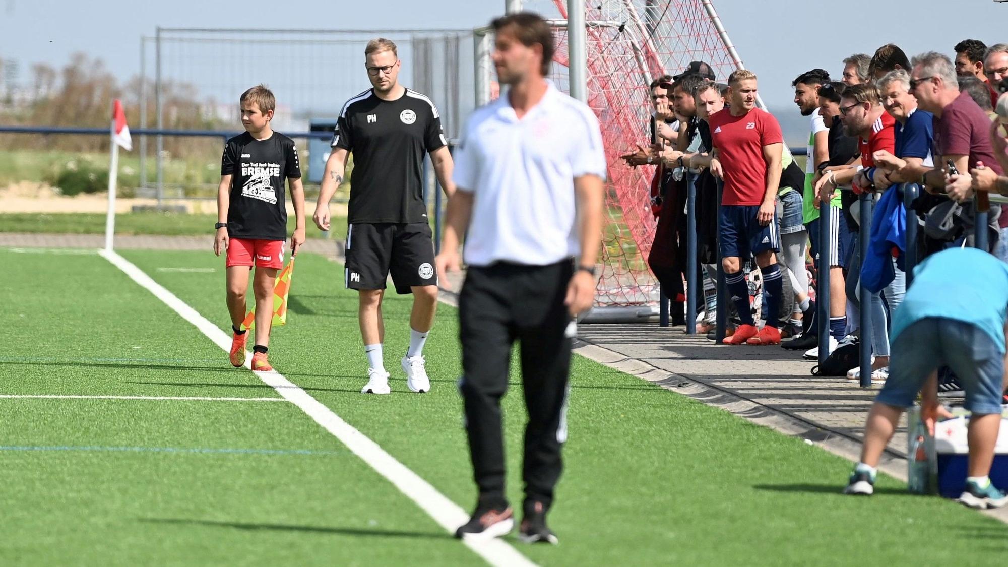 Die beiden Trainer an der Seitenlinie. Im Hintergrund scharf ist Lommersums Trainer Philipp Henn, im Vordergrund unscharf ist Zülpichs Marc Altendorf.