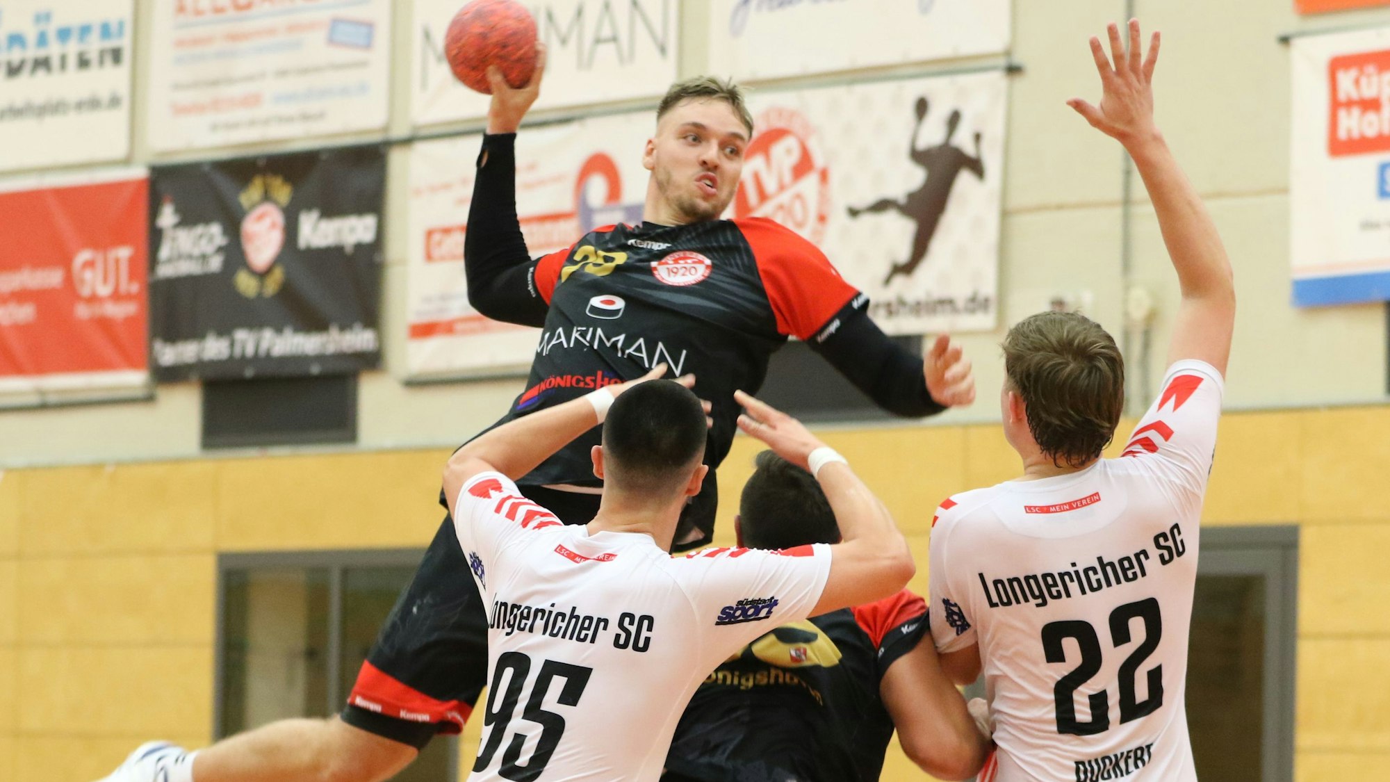 Robin Voiß springt in zwei Gegenspieler und einen Mitspieler hinein.