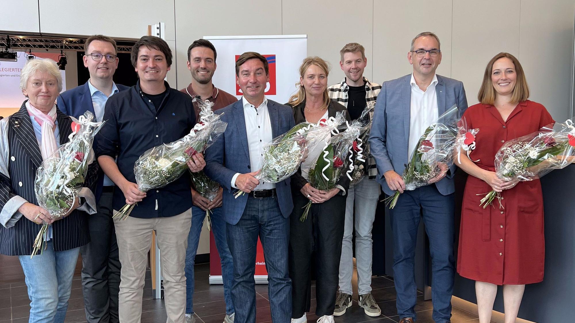 Nach ihrer Wahl haben sich die Mitglieder des SPD-Kreisvorstands um den Vorsitzenden Sebastian Hartmann mit Blumensträußen zum Gruppenfoto aufgestellt.