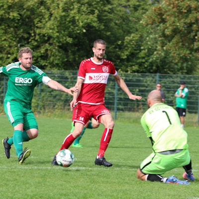 Ein Mechernicher Spieler versucht, den Ball am Torwart vorbei zu schießen.