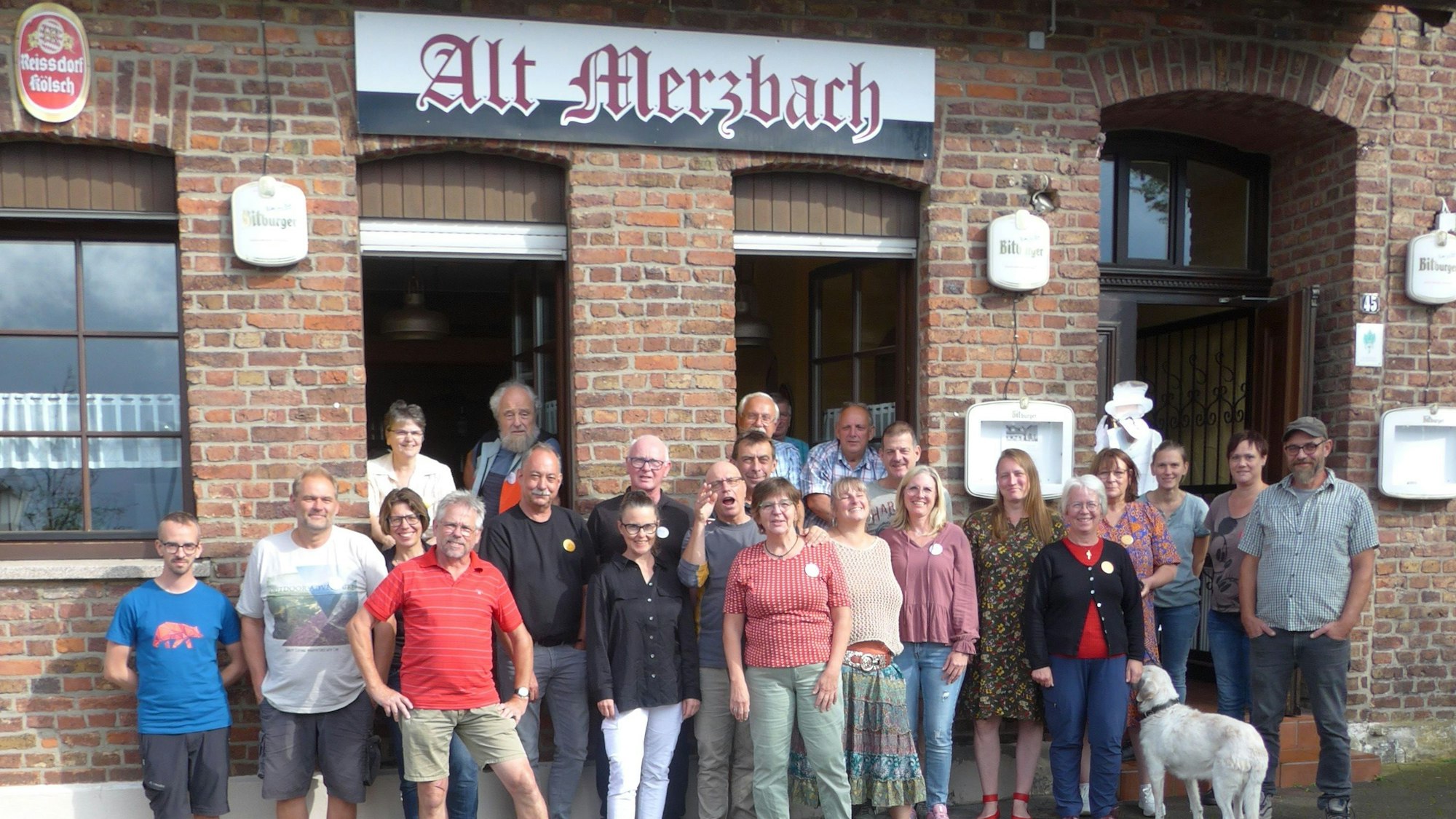 24 Mitglieder umfasst die Genossenschaft zur Rettung der Traditionskneipe Alt Merzbach, die vor der Kneipe stehen.