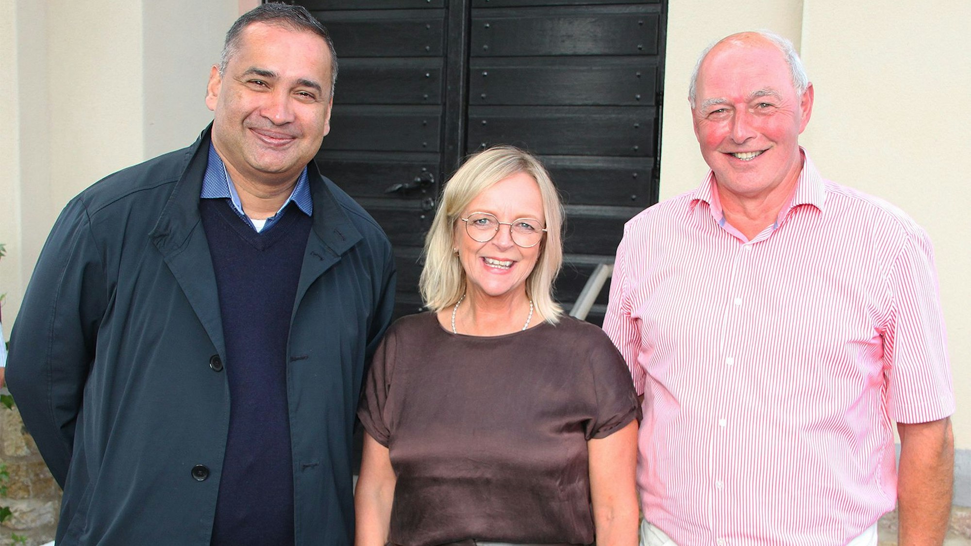 Pfarrer Robert Rego, Bürgermeisterin Sabine Preiser-Marian und Dieter Hufschmidt stehen vor der Kirche.