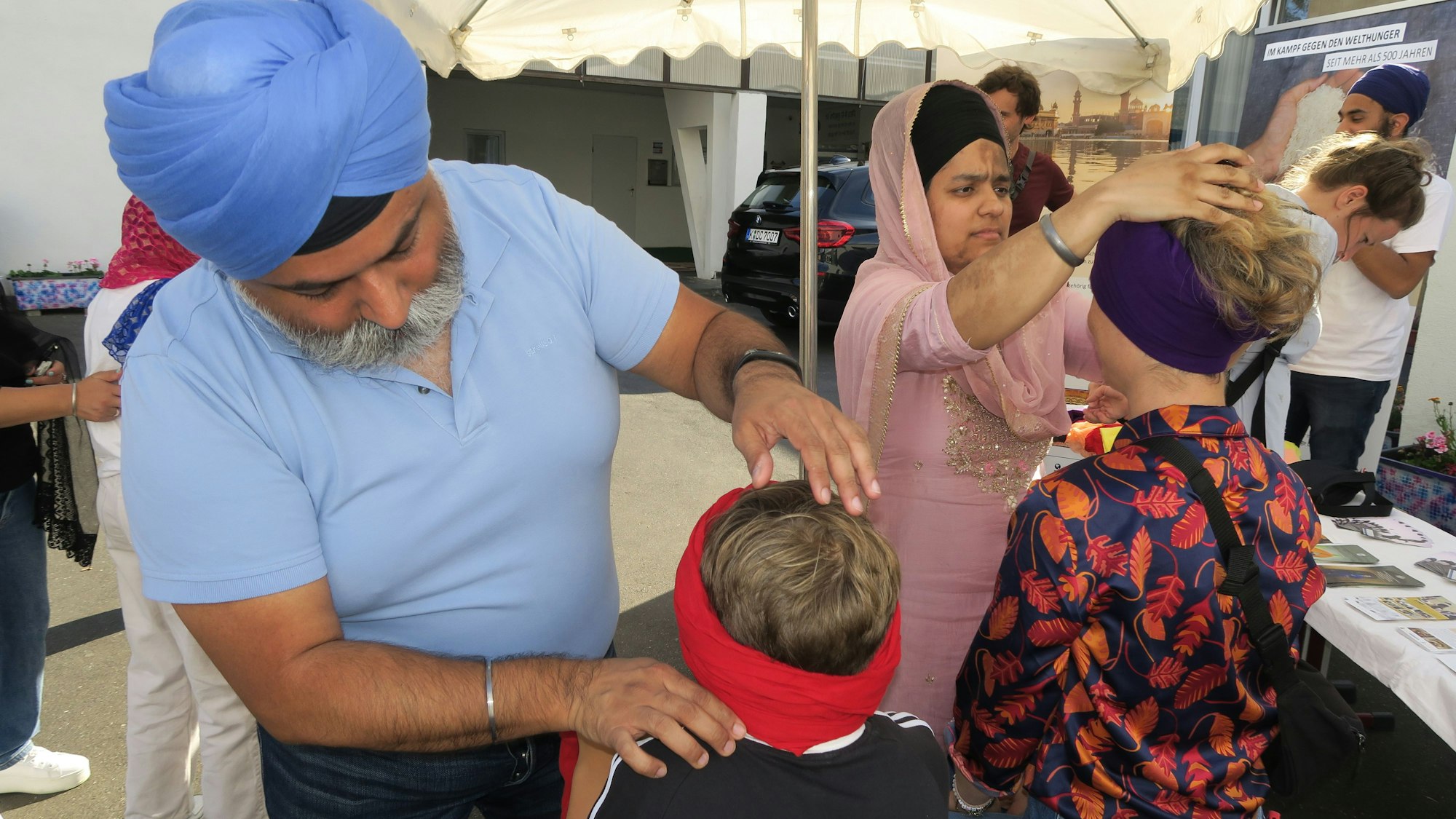 Zwei Kindern werden Turbane gebunden